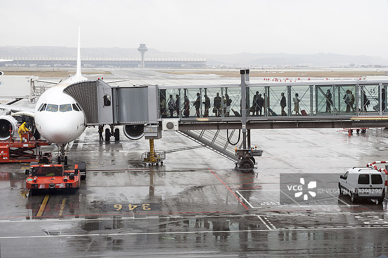 乘客通过廊桥登上飞机图片素材
