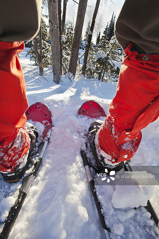 穿红色绑腿和红色雪鞋的人从后背穿过双腿的广角镜头特写图片素材