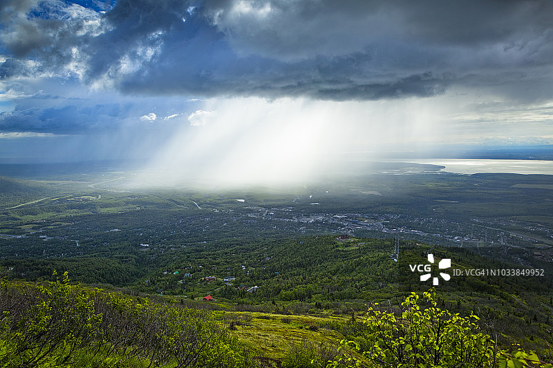 阳光穿透乌云照亮下方城市图片素材