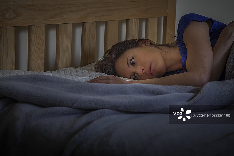 女人躺在床上睁着眼睛图片素材