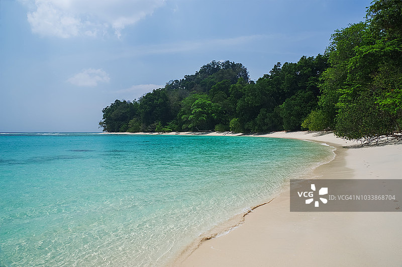 拥有白色沙滩、蓝色天空和碧绿海水的热带海滩图片素材