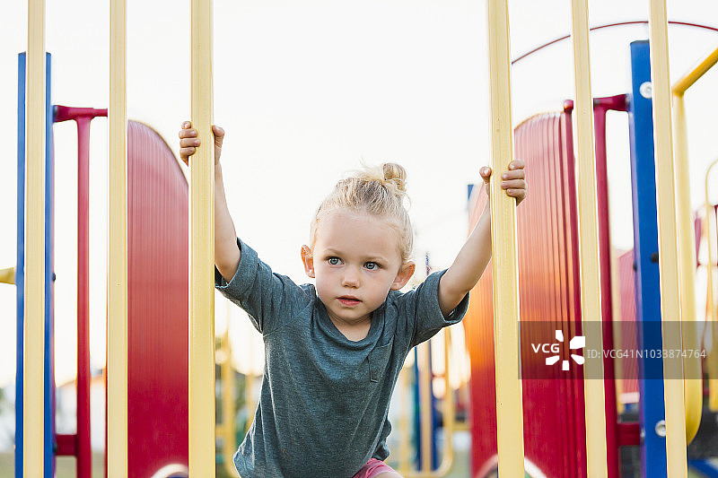 在游乐场攀爬岩石梯子的金发女孩图片素材