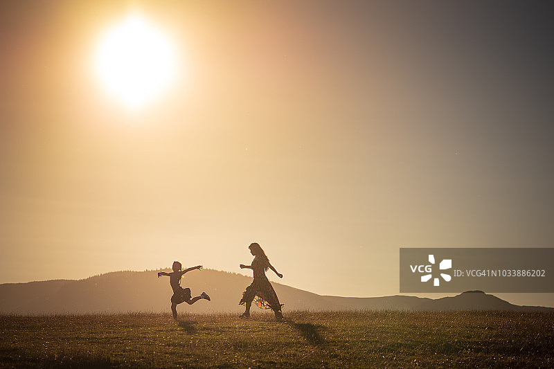 小女孩奔跑在英国凯西克乡村日落牧场图片素材