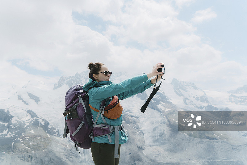在冰川背景下自拍的背包女人图片素材