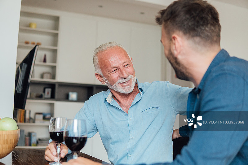 年迈父亲与成年儿子饮酒图片素材