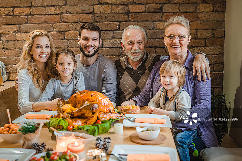 温馨的多代家庭在餐厅享用感恩节晚餐图片素材