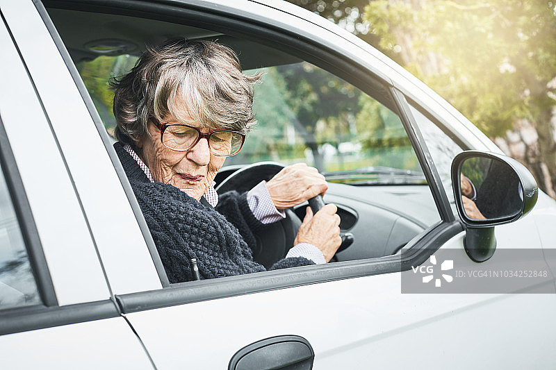 年长的女司机倒车时面露难色图片素材