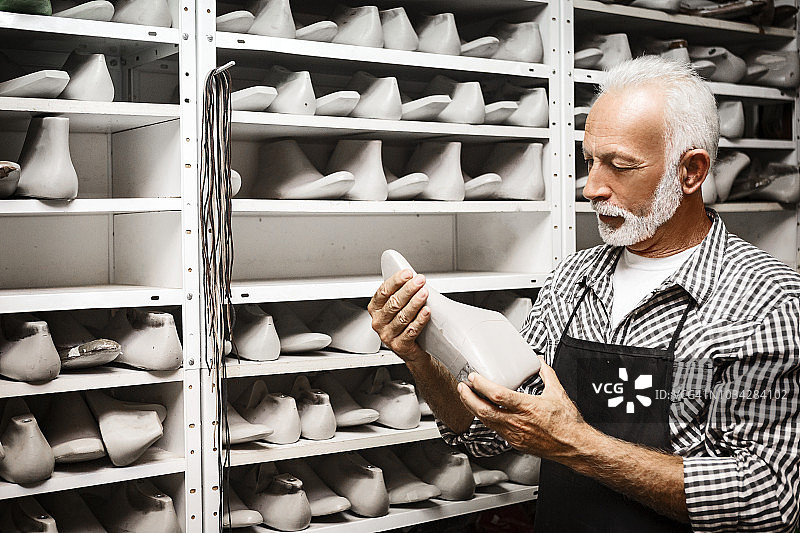 制鞋匠选择脚型测量模具图片素材