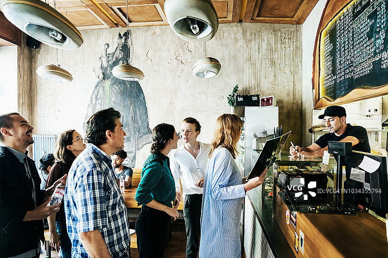 人们在繁忙的汉堡餐厅排队等候图片素材