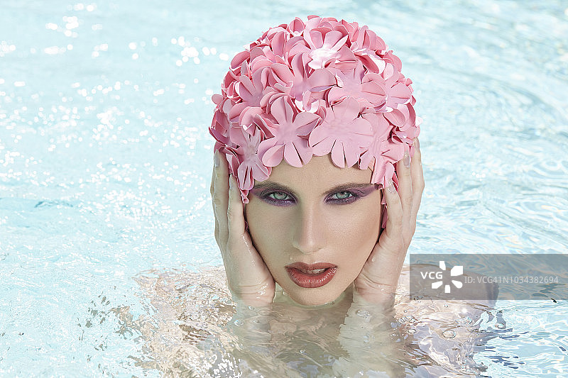 化妆的女士戴着粉色花朵发网在泳池中沐浴图片素材