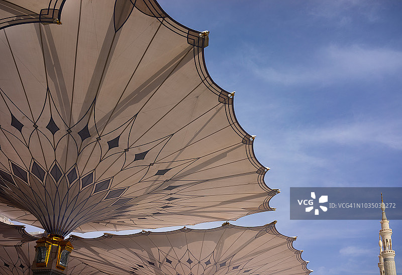 纳巴维清真寺的宣礼塔与巨型伞的清晨景色图片素材