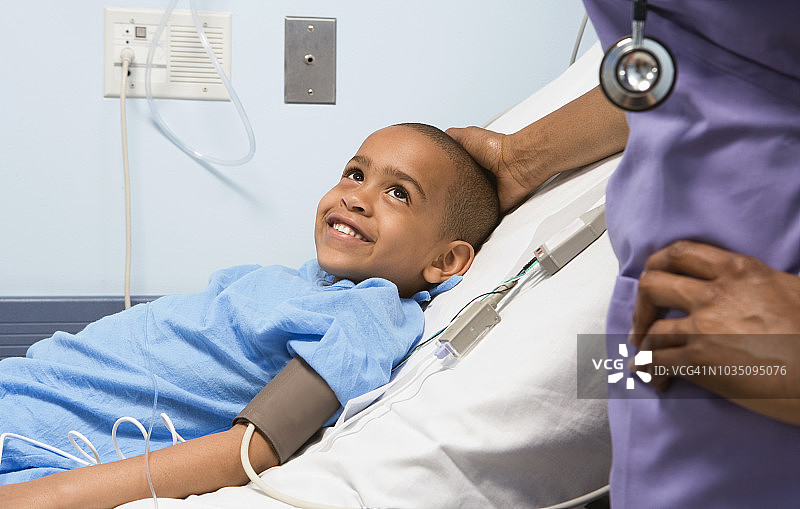 在医院病床上对着护士微笑的非洲男孩图片素材