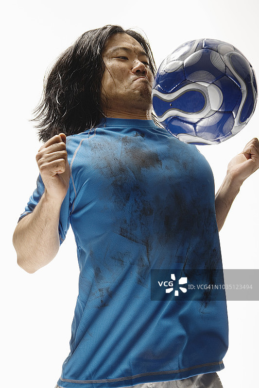 亚洲男性足球运动员用胸部颠球图片素材
