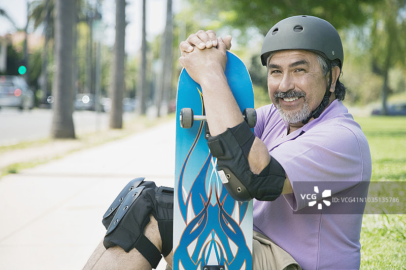 拿着滑板的西班牙裔男人图片素材