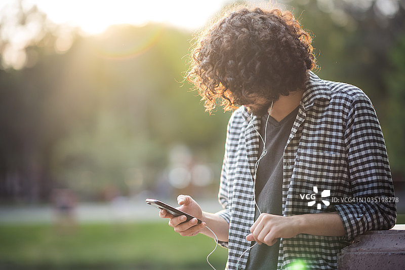 年轻男人在户外听音乐图片素材