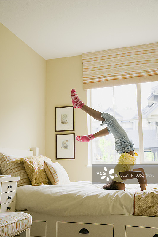 非洲裔女孩在床上倒立图片素材