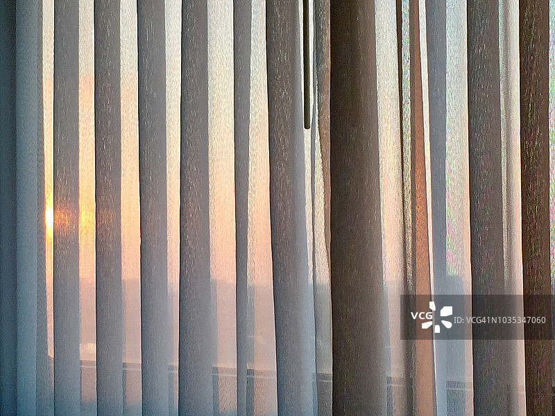 日出时分透过褶皱推拉帘看到的魔幻时刻图片素材