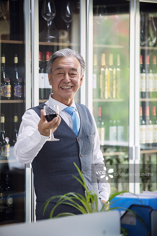 年长的商人品尝葡萄酒图片素材