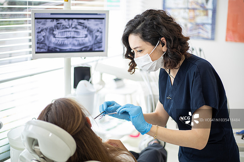 女牙医在牙科诊所和病人交谈图片素材