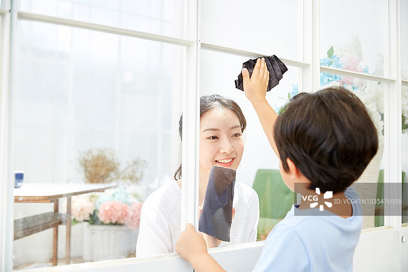 孩子和妈妈一起快乐地擦窗户图片素材