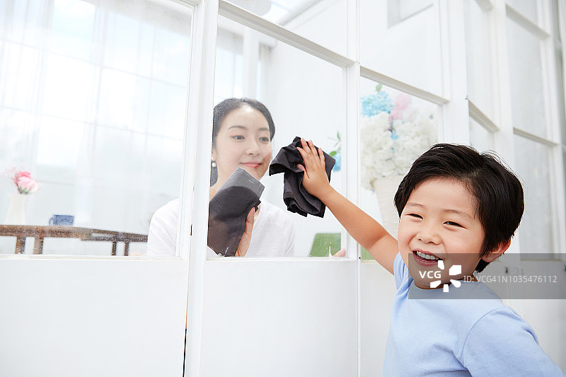 孩子和妈妈一起快乐地擦窗户图片素材