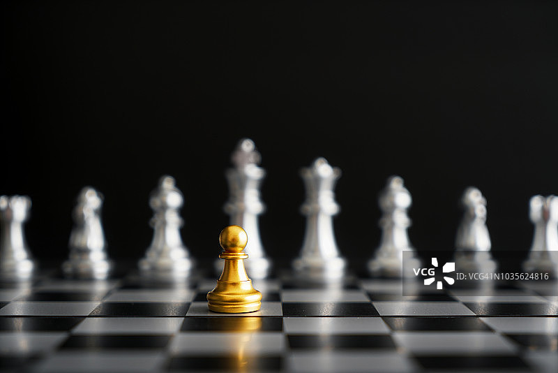 黑色背景上的金色棋子与银色棋子对弈：公司战略、商业胜利或决策概念图片素材
