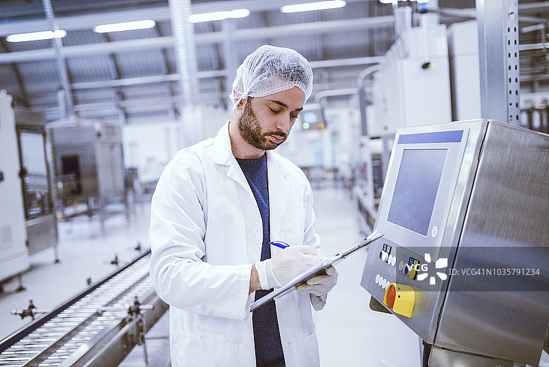 用剪贴板记录研究结果的年轻严肃的科学家图片素材