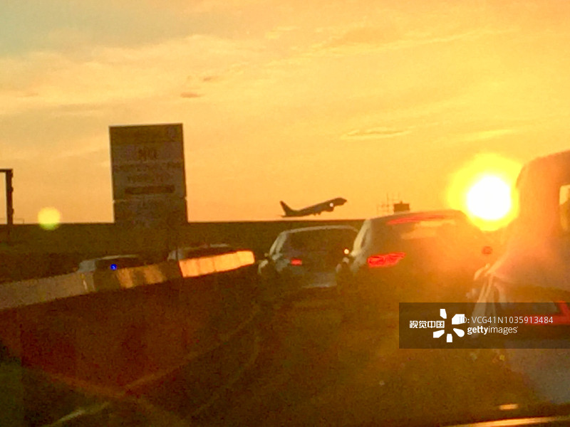 机场的魔幻时刻：驶向喷气机起飞的橙色朝阳图片素材