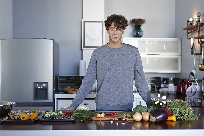 男美食视频博主在厨房准备蔬菜的视频制作肖像照图片素材
