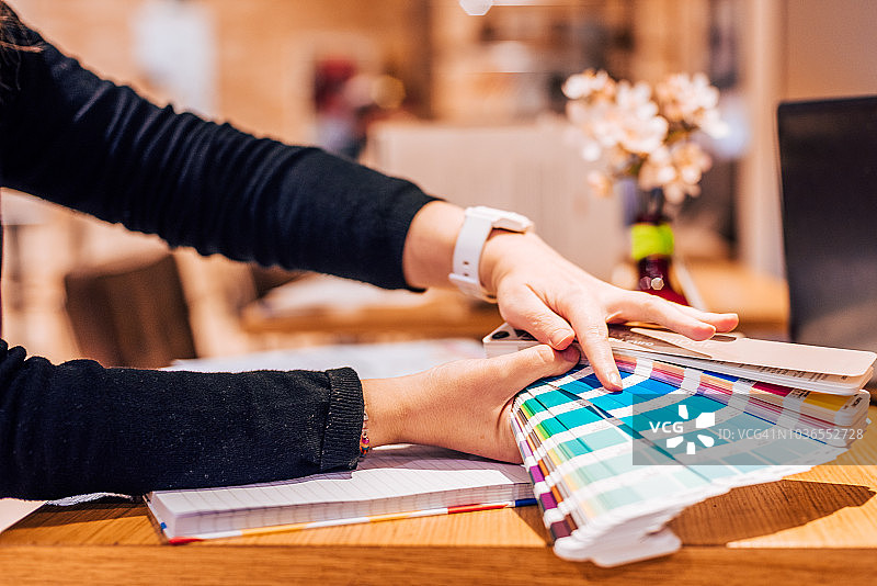 女人拿着潘通色卡（家居室内）的手部特写图片素材