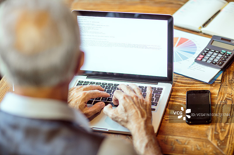 使用笔记本电脑工作的年长商人图片素材