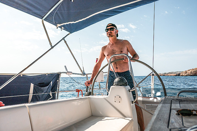 驾驶帆船的年轻男人图片素材