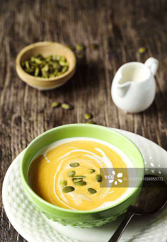 木质背景上的奶油南瓜籽南瓜汤图片素材