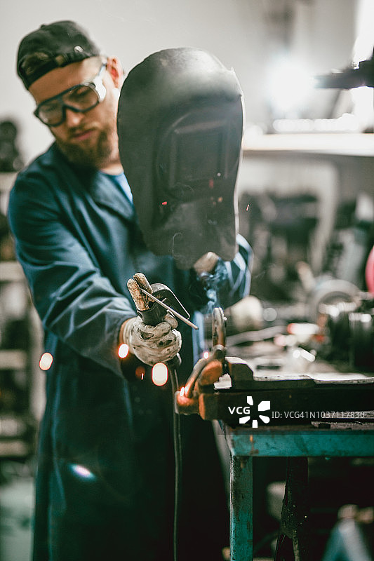 男焊工在车间修理更换零件图片素材