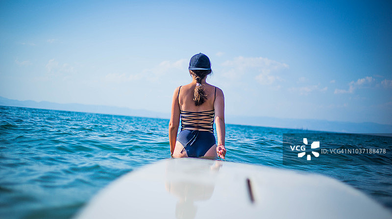 一名女子拖着冲浪板图片素材