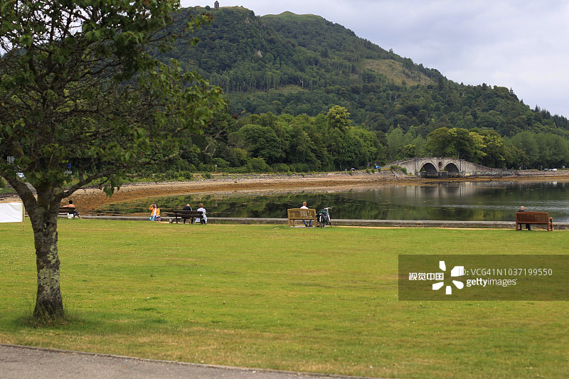 人们坐在长椅上欣赏苏格兰洛克费恩湖的景色图片素材
