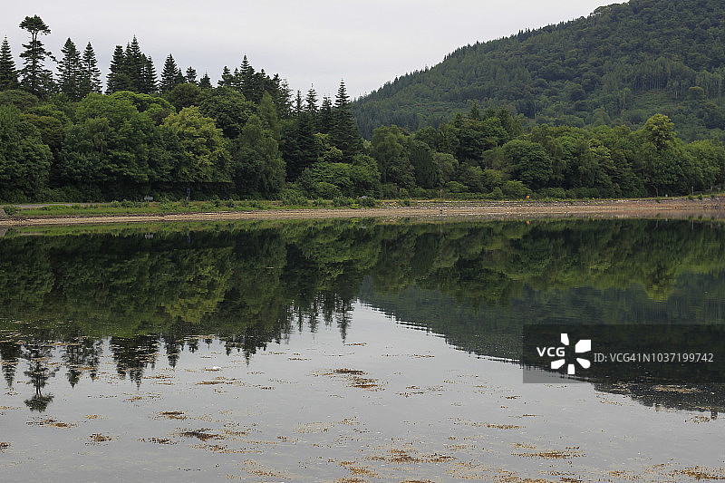 苏格兰洛赫费恩湖上葱郁的山丘倒影图片素材