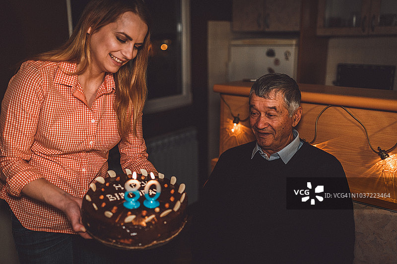 孙女为祖父的生日拿着生日蛋糕图片素材