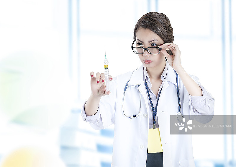 女护士将针头注入黄色液体疫苗图片素材