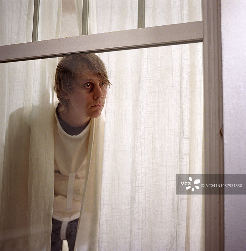 穿着束身衣、眼睛发黑的男人望着窗外图片素材