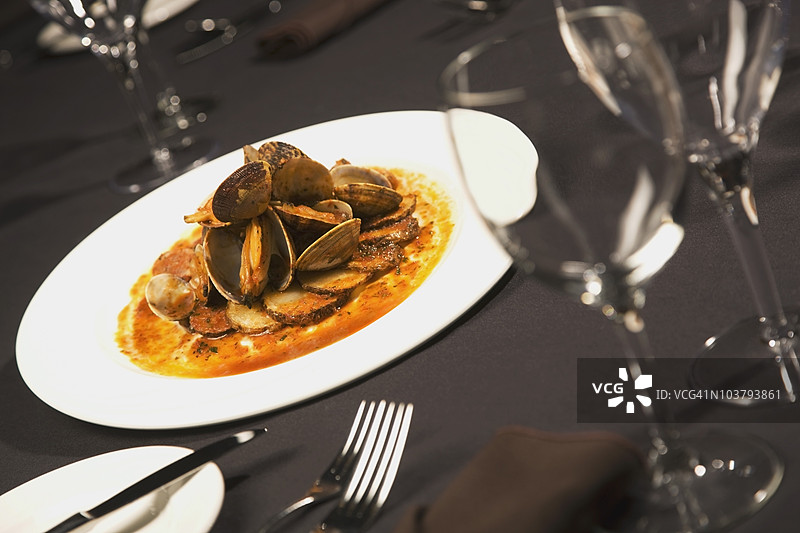 桌子上摆着一盘海鲜和酒杯图片素材