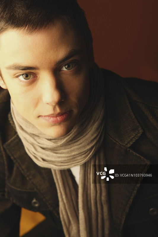 戴围巾穿夹克的年轻男子肖像图片素材