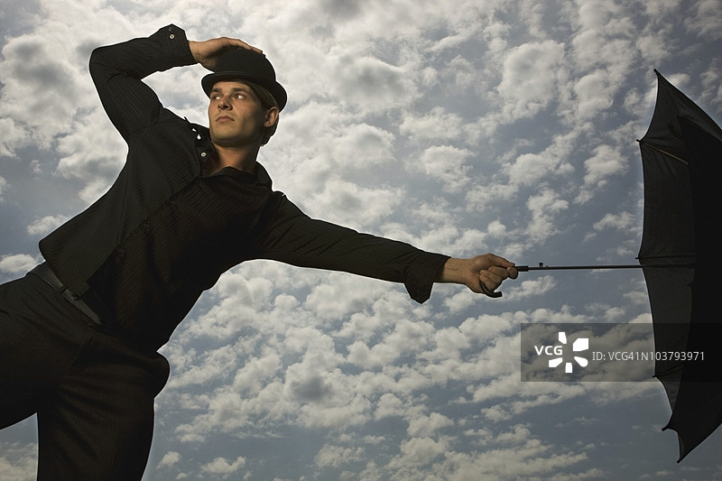 一个拿着雨伞并戴着高顶帽的男人图片素材
