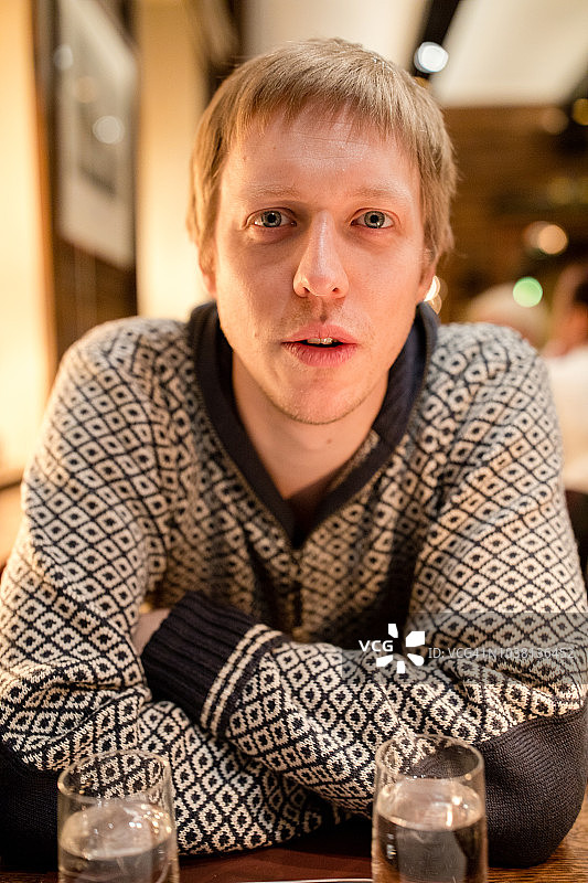 冬天，一个年轻男子坐在挪威卑尔根的一家餐馆里图片素材