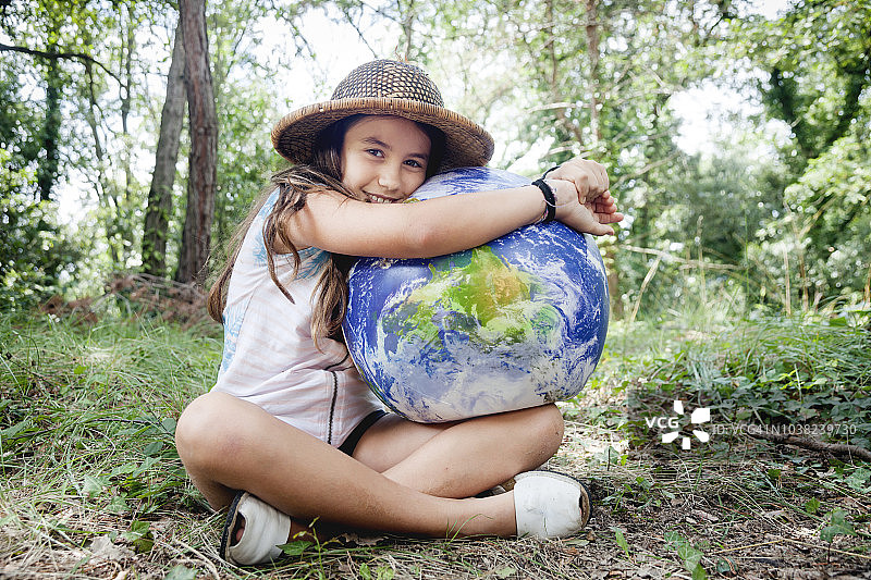 小女孩拥抱地球仪图片素材