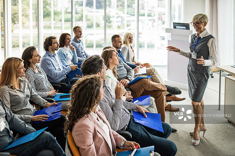 高兴的女领导在会议室给同事们做商业讲座图片素材