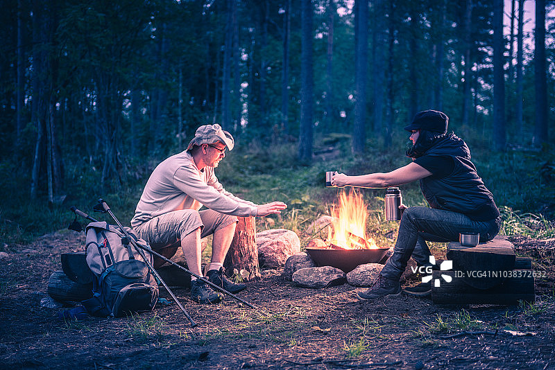 男人和女人们在森林里围着篝火图片素材