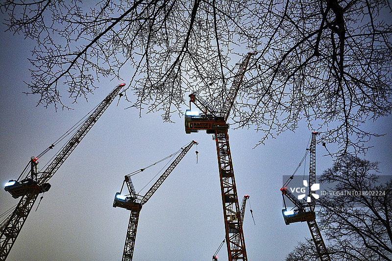 夜晚的塔式起重机与冬季光秃的树木，德国柏林图片素材