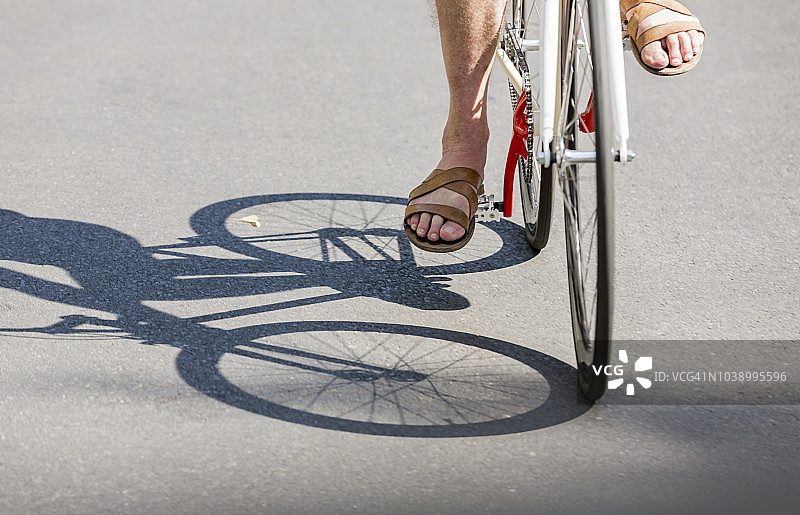 穿凉鞋骑时尚单速城市自行车的男人图片素材