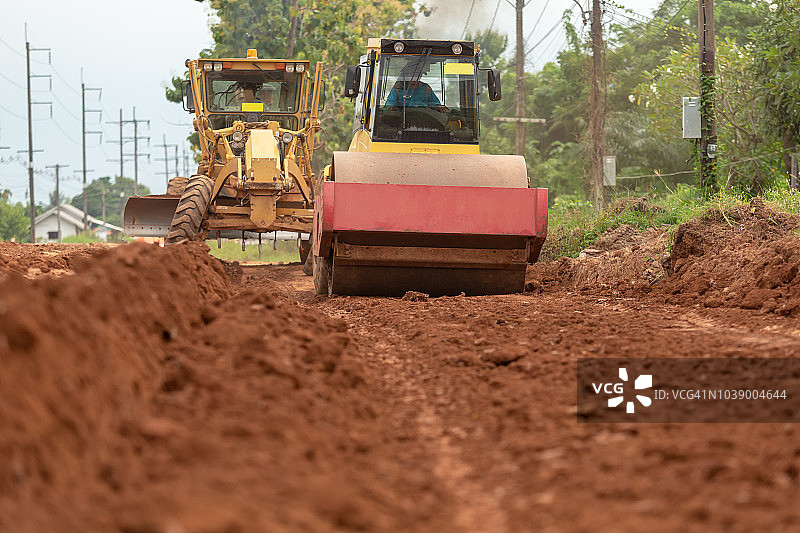 在高速公路建筑工地工作的黄色振动压路机图片素材